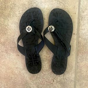 Black flip flops by Tory Burch